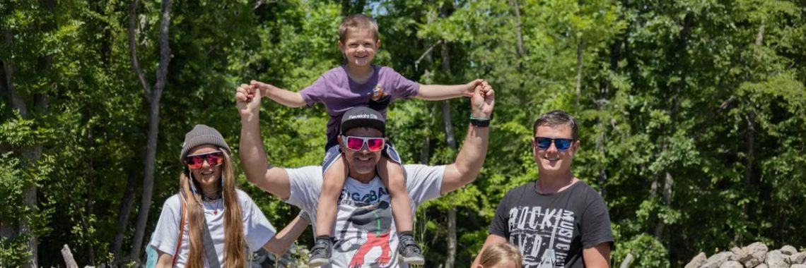 A joyful family enjoying a sunny day outdoors, captured in a lively and happy moment.